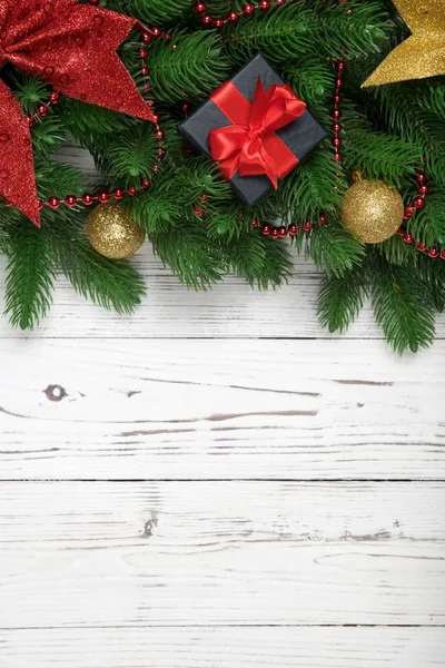 Decorazione invernale di Natale verticale con rami di abete e scatola regalo su sfondo in legno bianco — Foto Stock