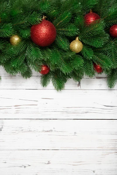 Juldekoration vintern vertikal med fir grenar på vit träskiva bakgrund — Stockfoto