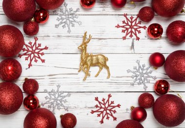 Beyaz ahşap zemin üzerinde Noel süsleri. Tatil ve kutlama yaratıcı kavramı. Yeni yıl kırmızı top, altın Ren geyiği ile kar tanesi. Düz yatıyordu