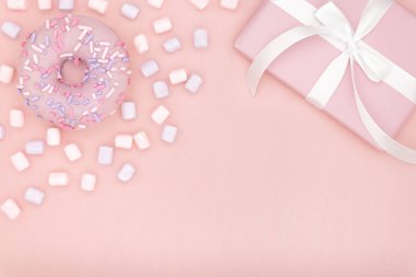 Sevgililer ya da Doğum günü üstten görünüm kompozisyon pembe hediyesi ile şekerli tatlı çörek ve hatmi mercan Kağıt arka plan üzerinde beyaz kurdele ile. Kavram dekor aşk gün veya gün. Düz yatıyordu. Kopya alanı