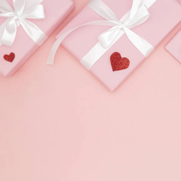 Декорации День святого Валентина на фоне стола вид сверху. Плоская композиция красной формы сердца и розовая коробка подарка с белой лентой коралловый бумажный фон для макета вашего дизайна. Концепция Дня любви — стоковое фото