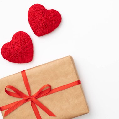 Tablo üstten görünüm arka plan dekorasyon Sevgililer günü. Düz kırmızı şekli kalp ve el sanatları kağıt hediye kutusu ile şerit bileşimi tasarımınızı mockup için beyaz zemin üzerinde yatıyordu. Aşk gün kavramı