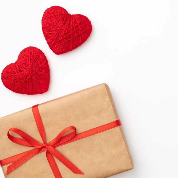 Tablo üstten görünüm arka plan dekorasyon Sevgililer günü. Düz kırmızı şekli kalp ve el sanatları kağıt hediye kutusu ile şerit bileşimi tasarımınızı mockup için beyaz zemin üzerinde yatıyordu. Aşk gün kavramı