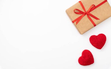 Sevgililer günü beyaz arka plan üzerinde izole kırmızı yay ve şerit üstten görünüm ile Kraft kağıt kutu mevcut. Düz yatıyordu. Uzay kopyalayın. Kompozisyon 8 Mart Kadınlar günü, anneler günü için hediye kutusu