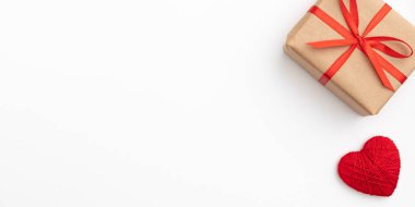 Sevgililer günü dekorasyon. Hediye kutu kırmızı kurdele ve beyaz arka plan üzerinde izole küçük kırmızı kalpler ile Kraft kağıt. Üstten görünüm. Aşk gün kavramı düz yatıyordu