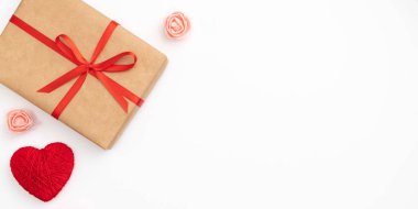 Sevgililer günü beyaz arka plan üzerinde izole kırmızı yay ve şerit üstten görünüm ile Kraft kağıt kutu mevcut. Düz yatıyordu. Uzay kopyalayın. Hediye kutusu ve 8 Mart Kadınlar günü, anneler günü için çiçek kompozisyon