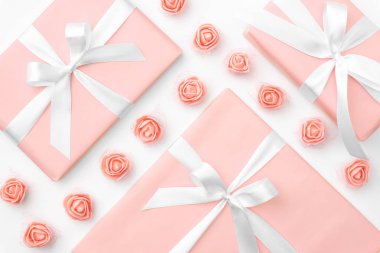 8 Mart Kadınlar günü tebrik kartı ile dekore edilmiş mercan veya pembe gül çiçek ve beyaz arka plan üzerinde izole mercan hediye kutusu. Anneler günü kavramı. Üstten görünüm. Düz yatıyordu