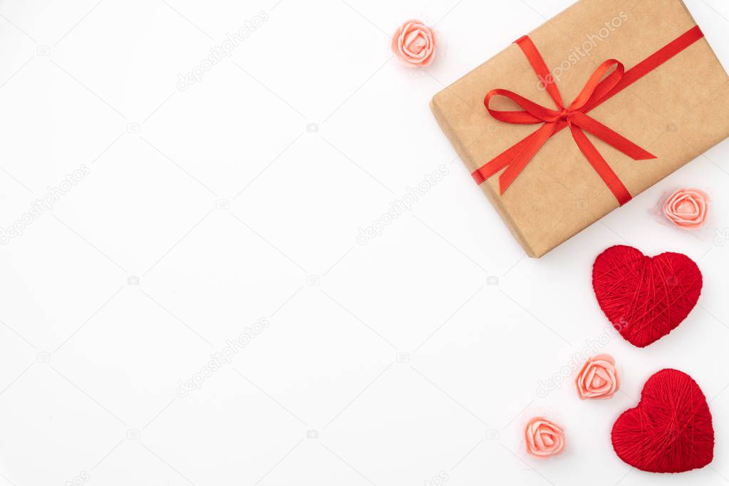 Present box of craft paper with red bow and ribbon top view for Valentines day isolated on white background. Flat lay. Copy space. Gifts box and floral composition for 8 march Womens day, Mothers day
