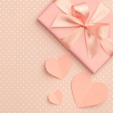 Sevgililer günü kompozisyon mevcut kutusu yay kurdele ile dekore edilmiş yaşam mercan renk arka plan üzerinde mercan küçük kalpler üstten görünüm. Kavram dekor hediye kutusu aşk gün veya Doğum günü için. Düz yatıyordu.