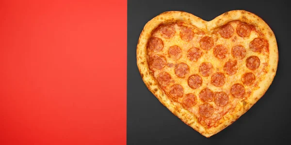 Пицца пепперони в форме сердца Концепция любви ко Дню Святого Валентина с сыром моцарелла, пепперони на красном и черном бумажном фоне — стоковое фото