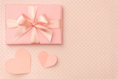 Sevgililer günü dekorasyon. Hediye kutusu şerit ve üzerinde yaşayan küçük mercan kalpleri ile mercan arka plan. Üstten görünüm. Aşk gün kavramı düz yatıyordu