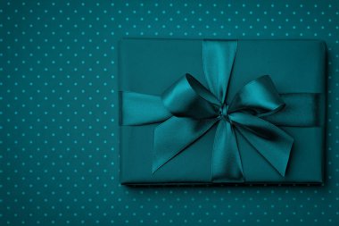 Koyu turkuaz hediye kutusu düz koyu turkuaz arka plan üzerinde yatıyordu. Kavramı kutu süsleme tatil üstten görünüm mevcut. Kopya alanı