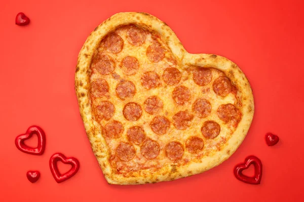 Srdíčkové pizza pepperoni pro valentinky den na červené papírové pozadí — Stock fotografie