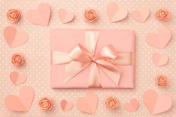 Поздравительная открытка на день Святого Валентина с украшенным бумажным сердцем, коралловыми или розовыми цветами роз и коралловой подарочной коробкой на белом фоне. Вид сверху. Плоский лежал — стоковое фото