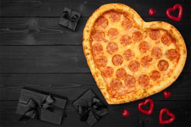 Pizza için Sevgililer günü romantik kavramı kopya alanı rustik koyu siyah arka plan üzerine hediye kutusu ile kalp şeklinde. Üstten görünüm. Düz yatıyordu