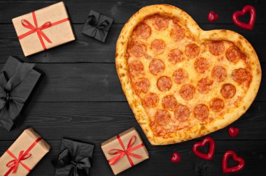 Pizza için Sevgililer günü romantik kavramı kopya alanı rustik koyu siyah arka plan üzerine hediye kutusu ile kalp şeklinde. Üstten görünüm. Düz yatıyordu