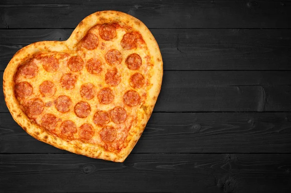 Corazón de pizza para el día de San Valentín romántico espacio de copia concepto sobre fondo negro oscuro rústico. Vista superior. Puesta plana — Foto de Stock