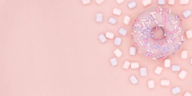 Çörek ve hatmi şekerli tatlı renkli sprinkles düz ile pastel mercan Kağıt arka plan üzerinde yatıyordu. Halka en az kavramı. Kopya alanı