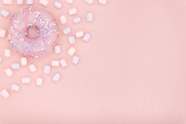 Çörek ve hatmi şekerli tatlı renkli sprinkles düz ile pastel mercan Kağıt arka plan üzerinde yatıyordu. Halka en az kavramı. Kopya alanı