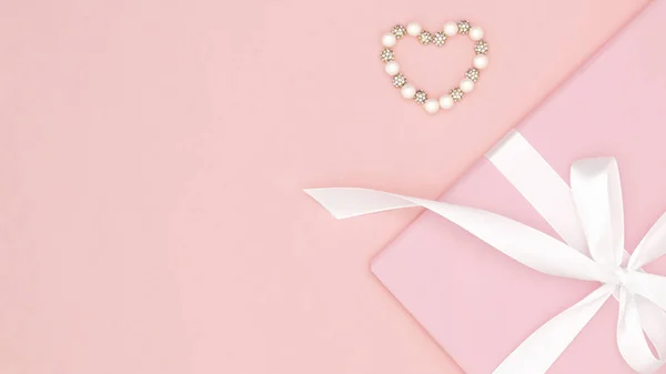 День святого Валентина или женщин розовый подарок с белой лентой лук украшен маленькими сердцами на коралловом бумажном фоне. Концепция декора день любви или день рождения. Плоский лежал. Копирование пространства — стоковое фото