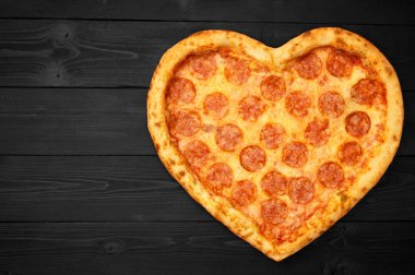 Pizza kalp için Sevgililer günü romantik kavramı kopya alanı rustik koyu siyah arka plan üzerine. Üstten görünüm. Düz yatıyordu.