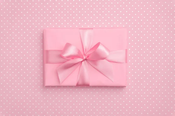Caja de regalo con lazo de cinta rosa en vista superior de fondo moteado rosa. El concepto de vacaciones, el regalo de cumpleaños, el año nuevo o la caja de regalo de Navidad presenta Navidad. Felicitaciones con espacio para copias. Piso Lay — Foto de Stock