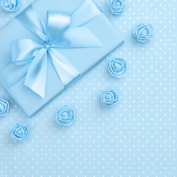 Coffret cadeau bleu décoré au printemps et fleurs roses vue du dessus pour 8 Mars Journée des femmes copier l'espace sur fond de papier bleu pastel. Modèle de fête des mères avec boîte cadeau. Pose plate. Collection printanière — Photo