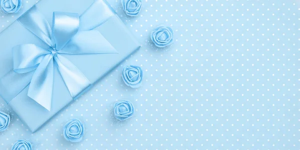 春天装饰蓝色礼品盒和玫瑰花顶部看法为3月8日妇女天拷贝空间在柔和的蓝色纸背景。带当前框的母亲节模板。平躺着。春季系列 — 图库照片