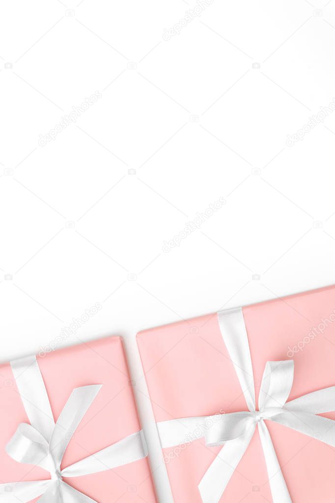 Pink Gift box with white ribbon bow isolated on white background top view. Holiday concept, birthday gift, New year or Christmas gift box presents Xmas. Congratulations with copy space. Flat Lay