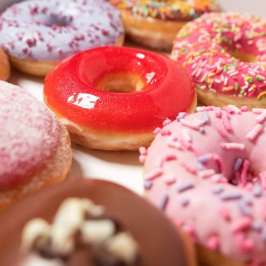 Beyaz arka planda pasta teslimi için kutuda farklı dolgular ile çok çeşitli Donuts. Tatlı Fast-Food konsepti. Kahvaltıda fırında lezzetli tatlı donut kek. Çörek makro koleksiyonu