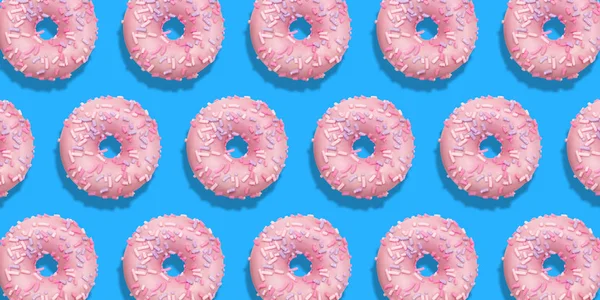 Creative pattern pink donuts flat lay on pastel blue background. Minimal sweet food concept. Surreal doughnuts coral color cake top view for bakery. Abstract summer donut dessert