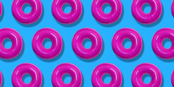 Yaratıcı desen pembe Donuts düz pastel mavi arka planda yatıyordu. Minimal tatlı gıda kavramı. Ekmek için gerçeküstü donut kek üst görünümü. Soyut yaz donut tatlı