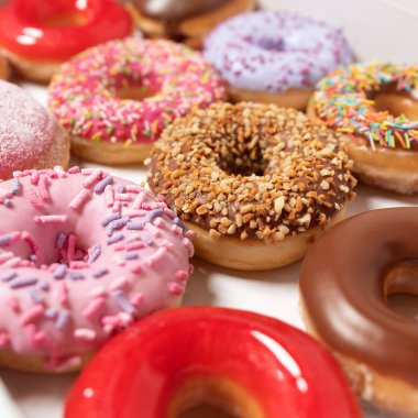 Beyaz arka planda pasta teslimi için kutuda farklı dolgular ile çok çeşitli Donuts. Tatlı Fast-Food konsepti. Kahvaltıda fırında lezzetli tatlı donut kek. Çörek makro koleksiyonu