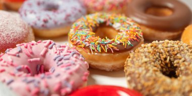 Beyaz arka planda pasta teslimi için kutuda farklı dolgular ile çok çeşitli Donuts. Tatlı Fast-Food konsepti. Kahvaltıda fırında lezzetli tatlı donut kek. Çörek makro koleksiyonu