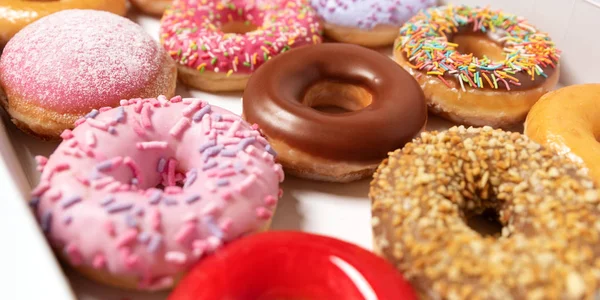 Beyaz arka planda pasta teslimi için kutuda farklı dolgular ile çok çeşitli Donuts. Tatlı Fast-Food konsepti. Kahvaltıda fırında lezzetli tatlı donut kek. Çörek makro koleksiyonu — Stok fotoğraf