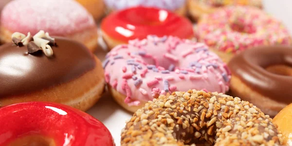 Closeup assorted donuts with different fillings in box for pastry delivery on white background. Sweet fast food concept. Tasty dessert doughnuts cake from bakery of breakfast. Donut macro collection Stock Image