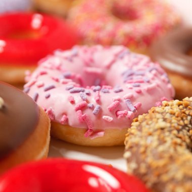 Beyaz arka planda pasta teslimi için kutuda farklı dolgular ile çok çeşitli Donuts. Tatlı Fast-Food konsepti. Kahvaltıda fırında lezzetli tatlı donut kek. Çörek makro koleksiyonu