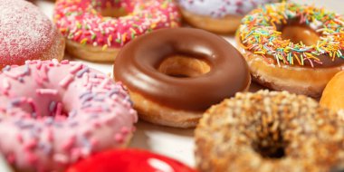 Beyaz arka planda pasta teslimi için kutuda farklı dolgular ile çok çeşitli Donuts. Tatlı Fast-Food konsepti. Kahvaltıda fırında lezzetli tatlı donut kek. Çörek makro koleksiyonu