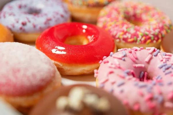 Closeup assorted donuts with different fillings in box for pastry delivery on white background. Sweet fast food concept. Tasty dessert doughnuts cake from bakery of breakfast. Donut macro collection