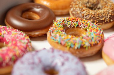 Beyaz arka planda pasta teslimi için kutuda farklı dolgular ile çok çeşitli Donuts. Tatlı Fast-Food konsepti. Kahvaltıda fırında lezzetli tatlı donut kek. Çörek makro koleksiyonu