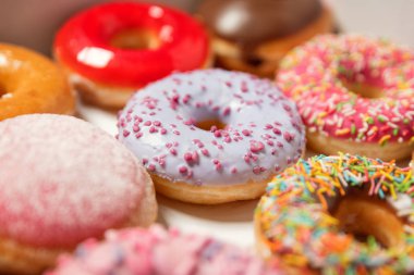 Beyaz arka planda pasta teslimi için kutuda farklı dolgular ile çok çeşitli Donuts. Tatlı Fast-Food konsepti. Kahvaltıda fırında lezzetli tatlı donut kek. Çörek makro koleksiyonu