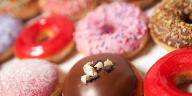 Beyaz arka planda pasta teslimi için kutuda farklı dolgular ile çok çeşitli Donuts. Tatlı Fast-Food konsepti. Kahvaltıda fırında lezzetli tatlı donut kek. Çörek makro koleksiyonu