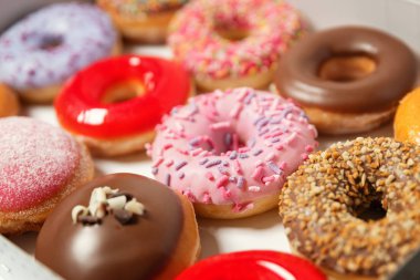 Beyaz arka planda pasta teslimi için kutuda farklı dolgular ile çok çeşitli Donuts. Tatlı Fast-Food konsepti. Kahvaltıda fırında lezzetli tatlı donut kek. Çörek makro koleksiyonu