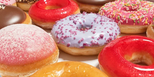 Donuts surtidos de primer plano con diferentes rellenos en caja para la entrega de pasteles sobre fondo blanco. Concepto de comida rápida dulce. La torta sabrosa de postre de las rosquillas de la panadería del desayuno. Donut macro colección — Foto de Stock