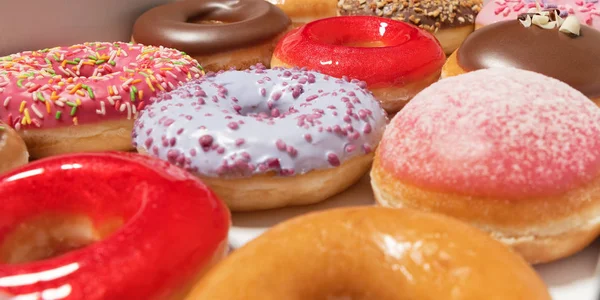 Beyaz arka planda pasta teslimi için kutuda farklı dolgular ile çok çeşitli Donuts. Tatlı Fast-Food konsepti. Kahvaltıda fırında lezzetli tatlı donut kek. Çörek makro koleksiyonu