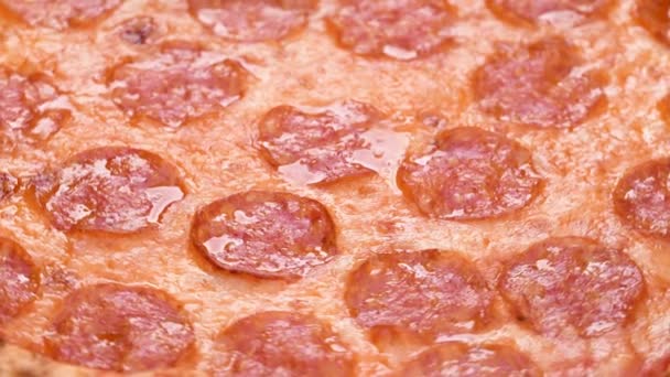 Pizza closeup with salami and cheese mozzarella 4k footage. Slow rotation of pepperoni pizza macro detail — Stock Video