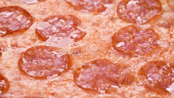 Пицца крупным планом с салями и сыром моцарелла 4k кадры. Медленное вращение деталей пиццы пепперони — стоковое видео