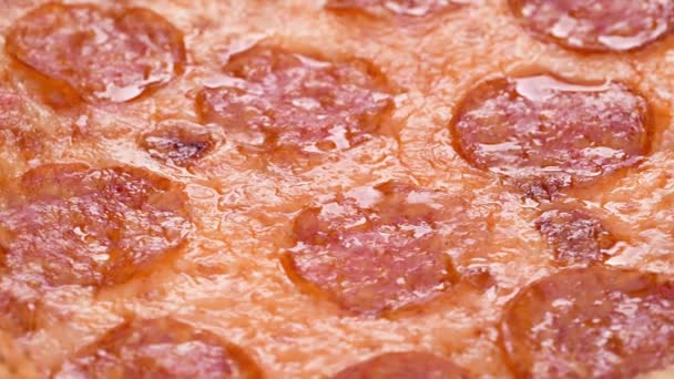 Pizza closeup with salami and cheese mozzarella 4k footage. Slow rotation of pepperoni pizza macro detail — Stock Video