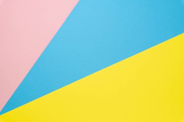 Mavi ve pembe, sarı pastel renkli kağıt düz arka plan yatıyordu. Üstte görüntü