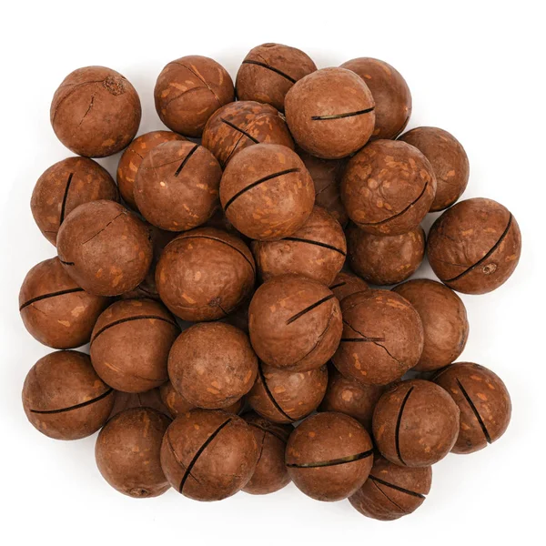 Nueces de macadamia en vista superior de concha aisladas sobre fondo blanco. Montón de nueces de macadamia de cerca. Alimentos ecológicos — Foto de Stock